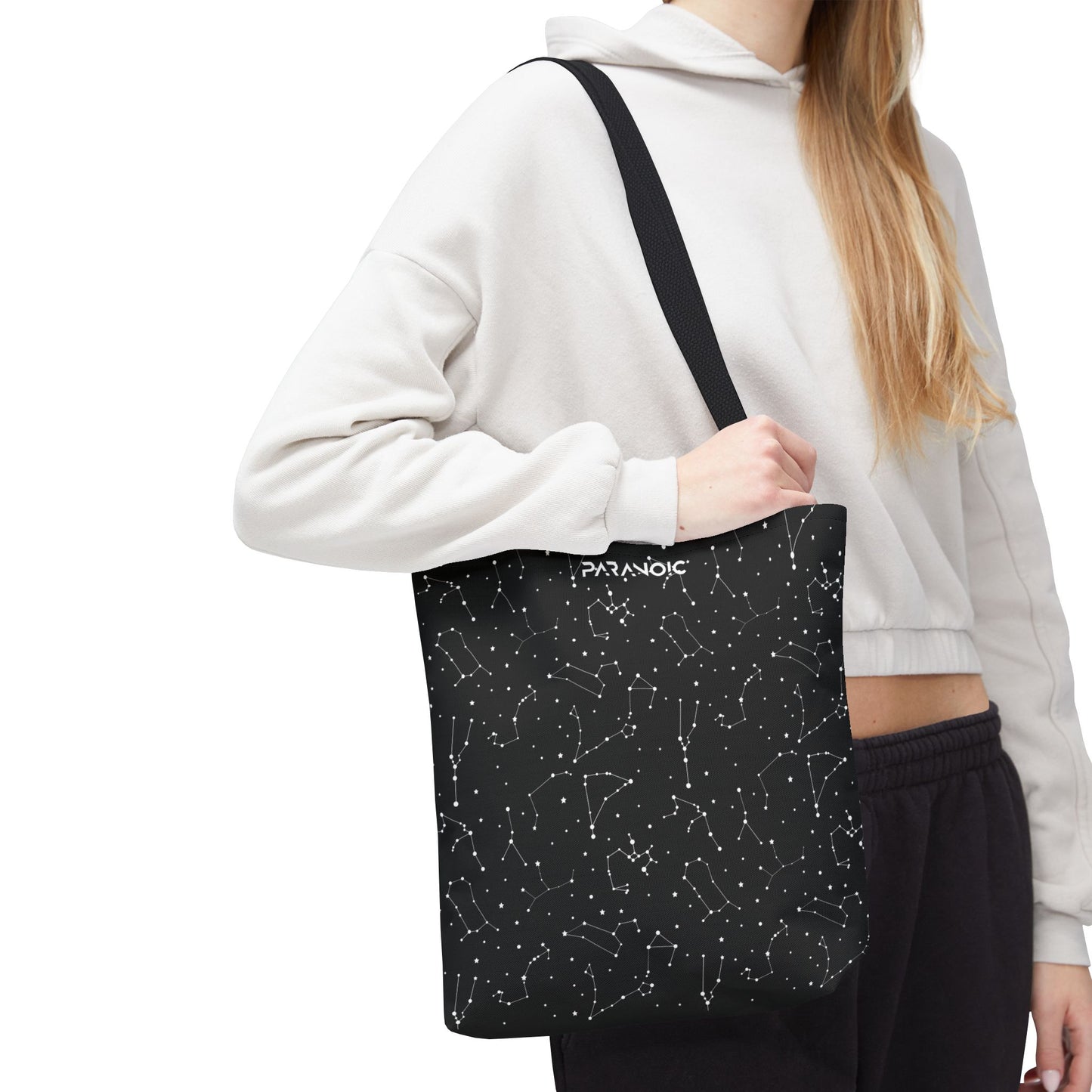 Model carrying the black Constellation tote bag, cropped below the head